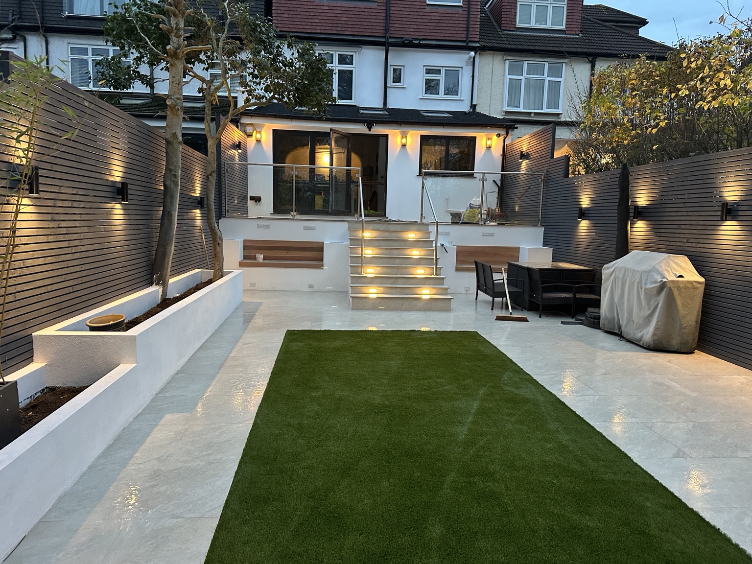 Modern landscaped garden after renovation with illuminated steps